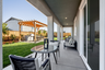 backyard with covered patio, grassy area, and wood pergola over built-in barbecue