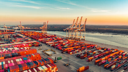 Shipping yard at sunrise full of containers and cranes