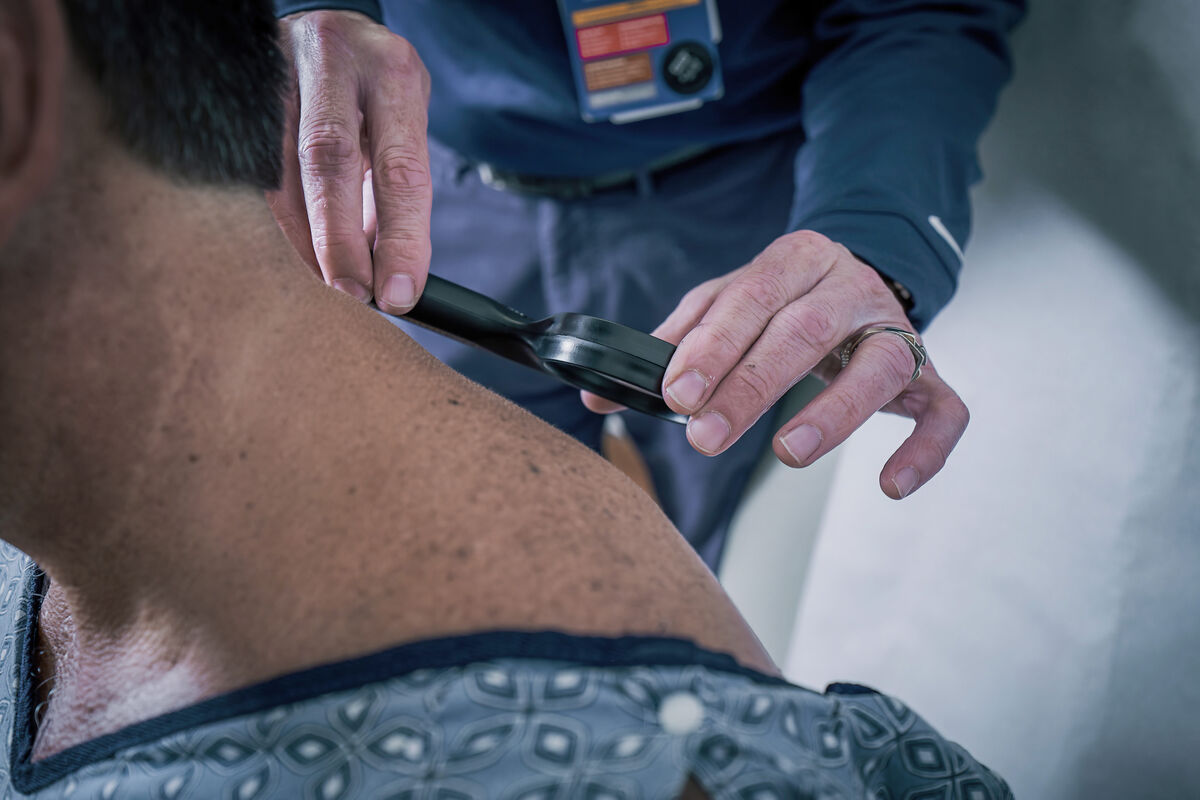 Doctor checks patient's skin for cancer