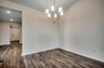 spacious area with hardwood flooring and gold chandelier lighting