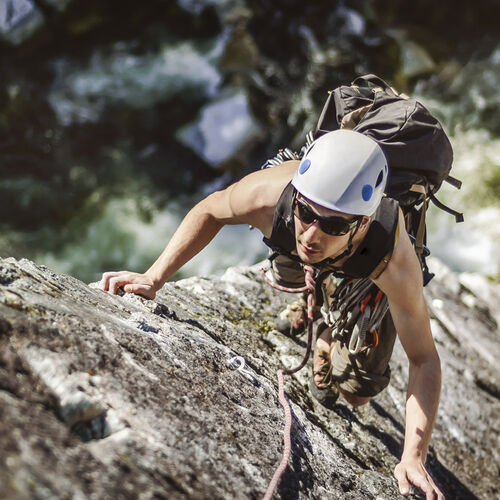 Man with HOYA sunglasses featuring special sportive lenses climbing a mountain