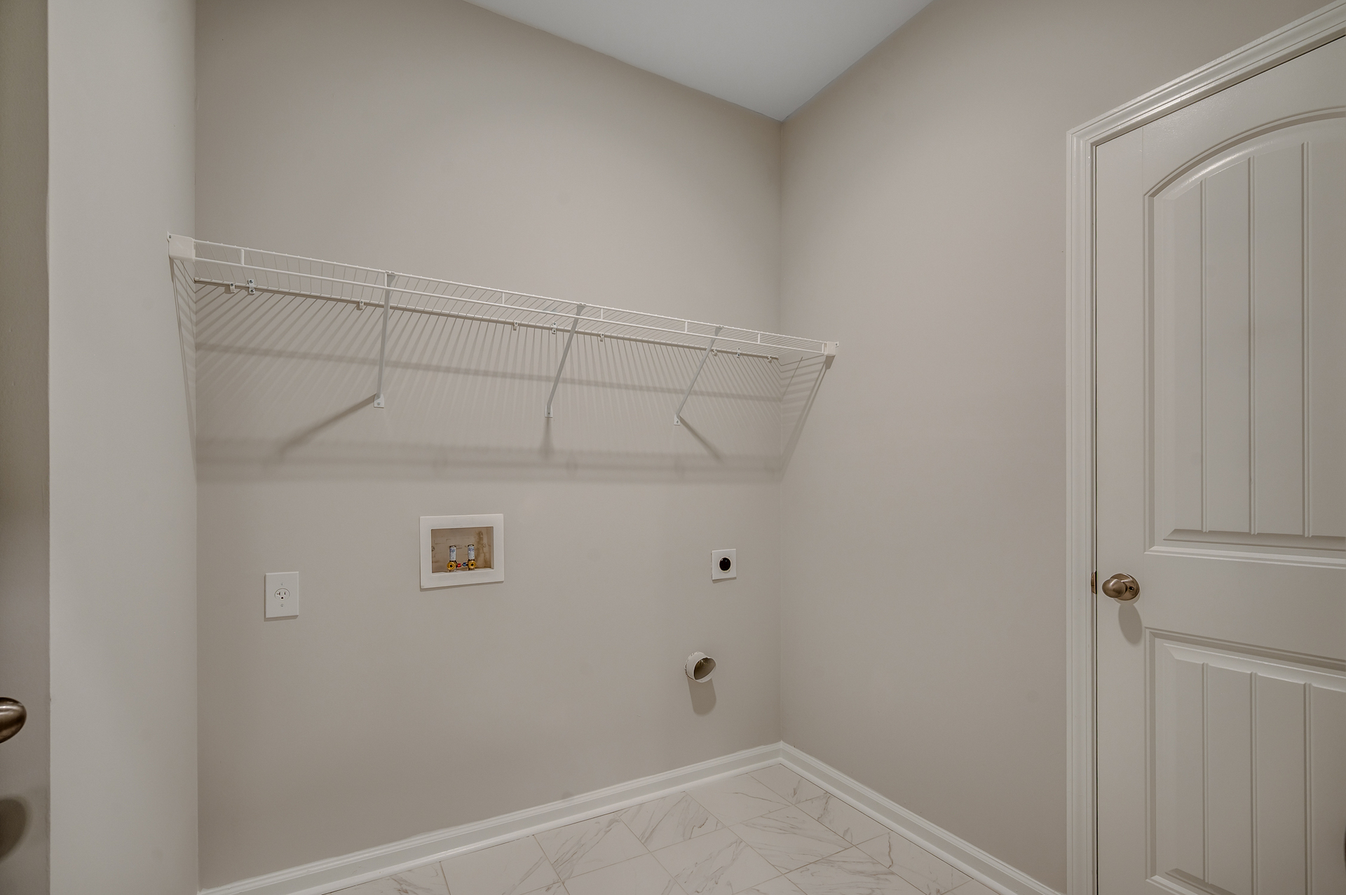 spacious room with tile flooring throughout, white wire shelving and tan walls