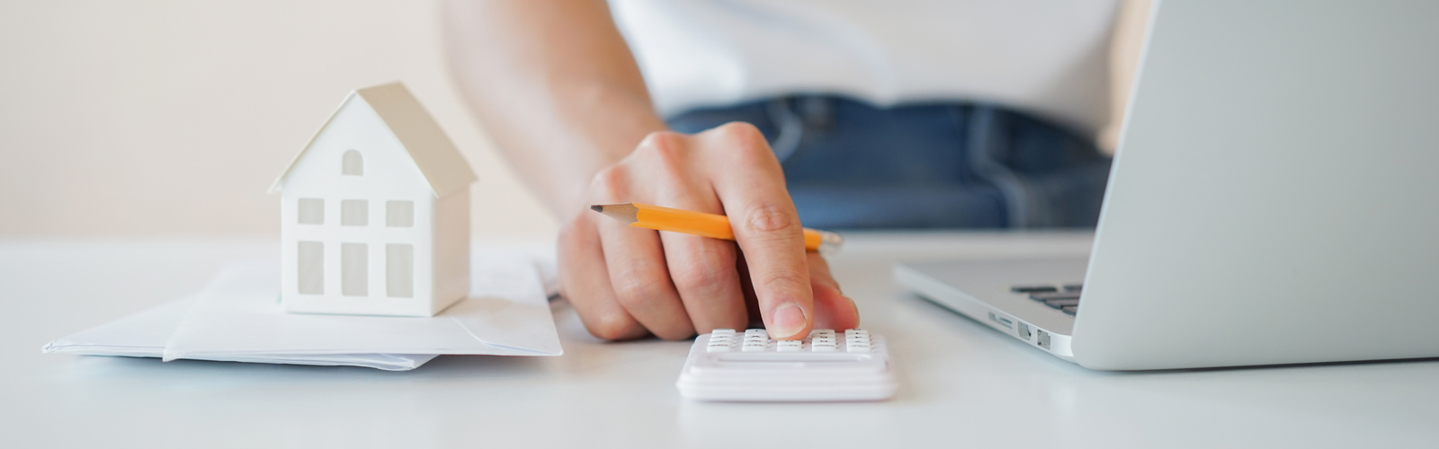 A person using a calculator and a laptop