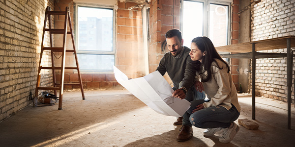 Couple looking at blueprints for their home under construction