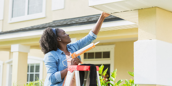 A woman making repairs to her home