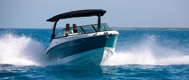 Couple in powerboat speeding through blue water towards you