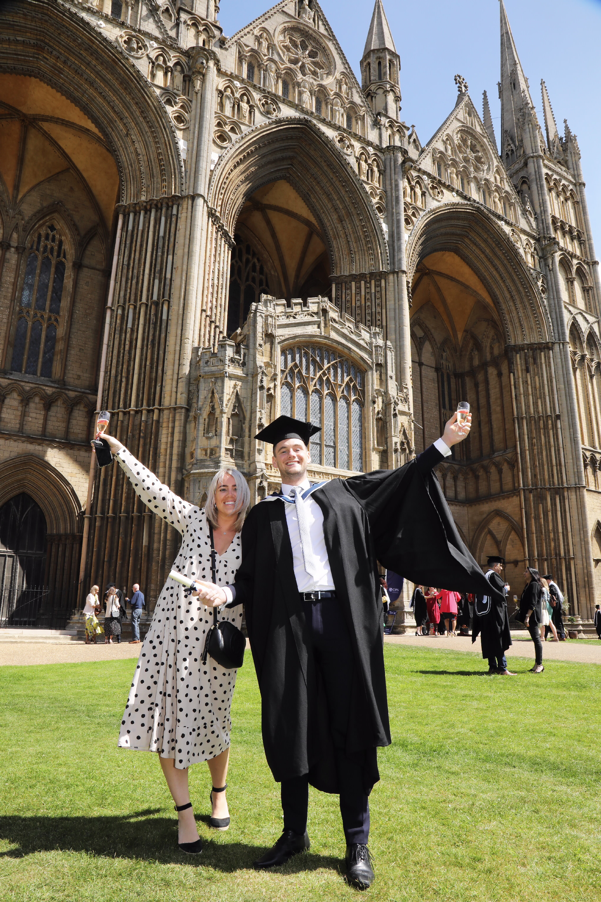 Two people celebrating with drinks outside the cathedral