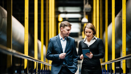 Man and woman in suits walking through an industrial building