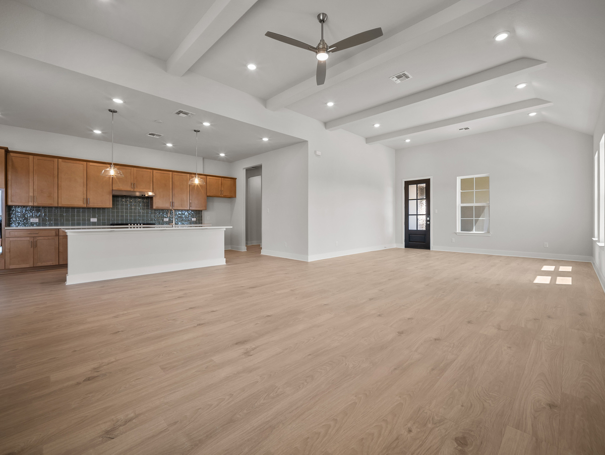 great room with brown flooring & beam ceilings