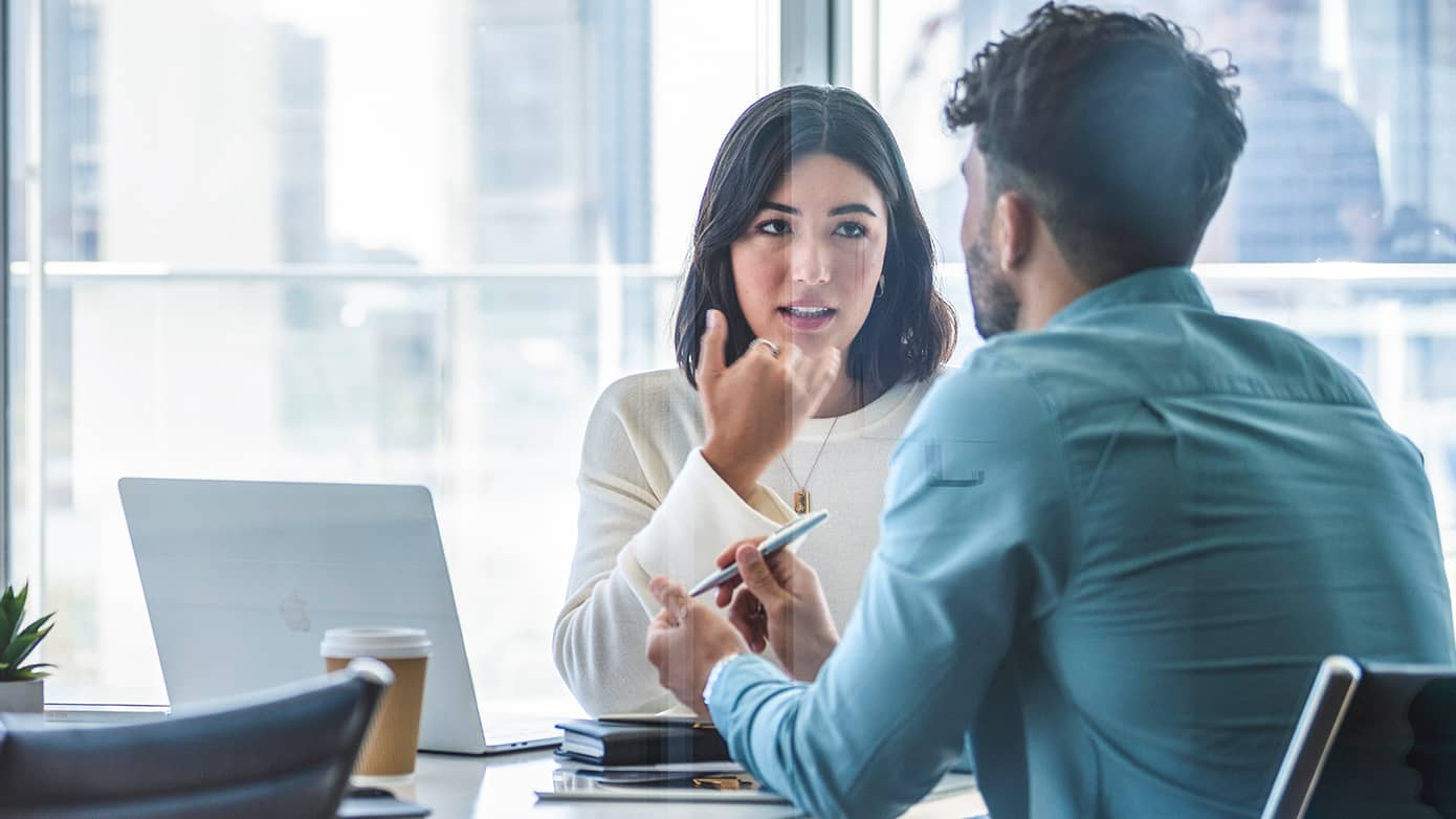 Office workers talking at a desk
