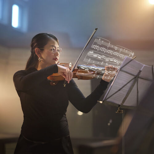 Female violinist wearing HOYA VisuPro lenses plays from sheet music