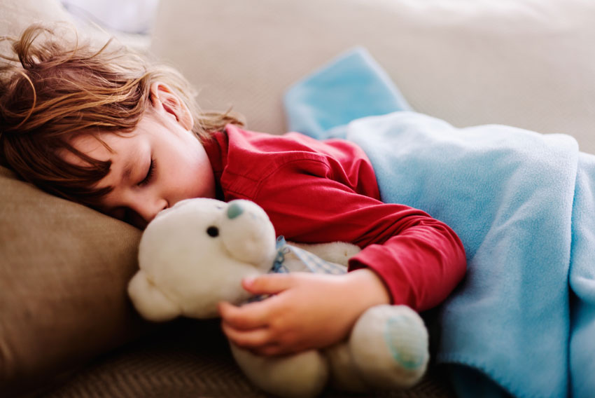 Vročinski krči pri dečku so minili – kljub vročini spi v postelji.