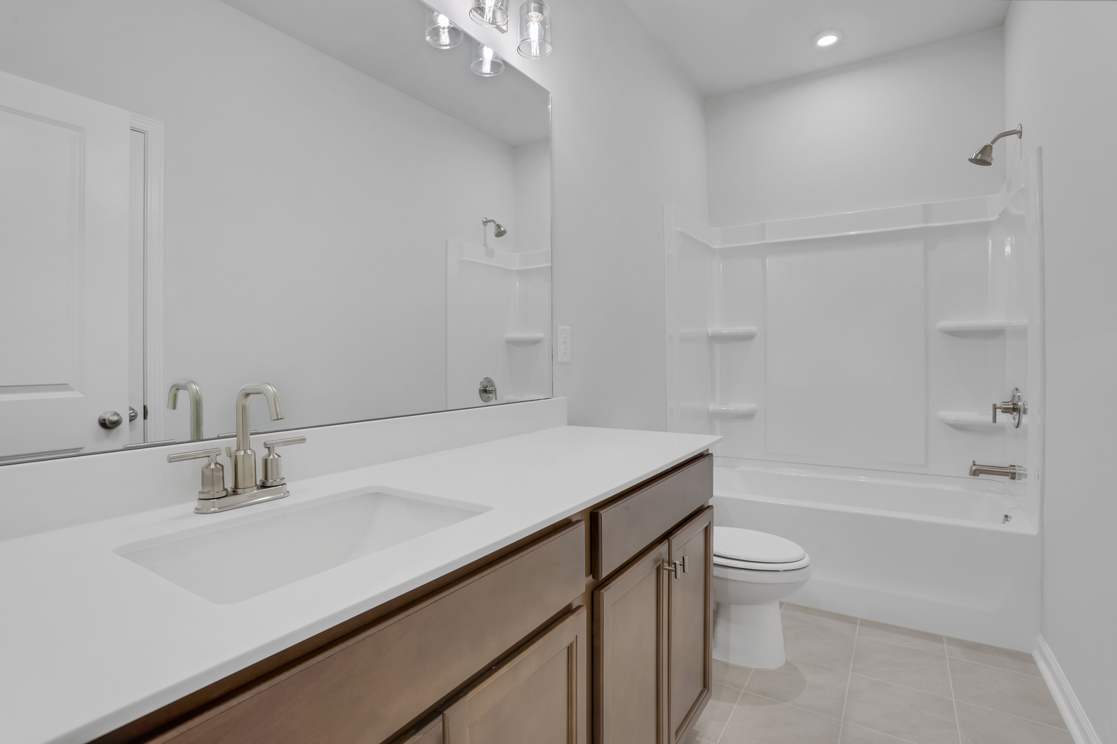 secondary bathroom with wood-finish cabinets and tile flooring