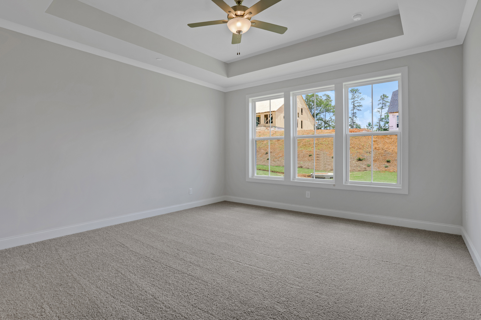 primary bedroom with windows and carpet