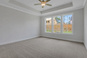 primary bedroom with windows and carpet