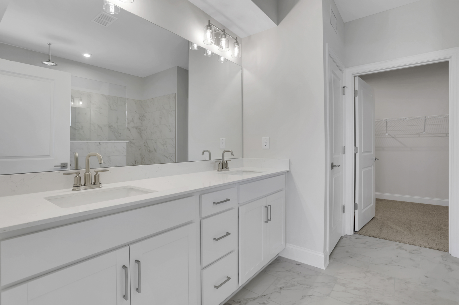 primary bathroom with white cabinets and tile flooring