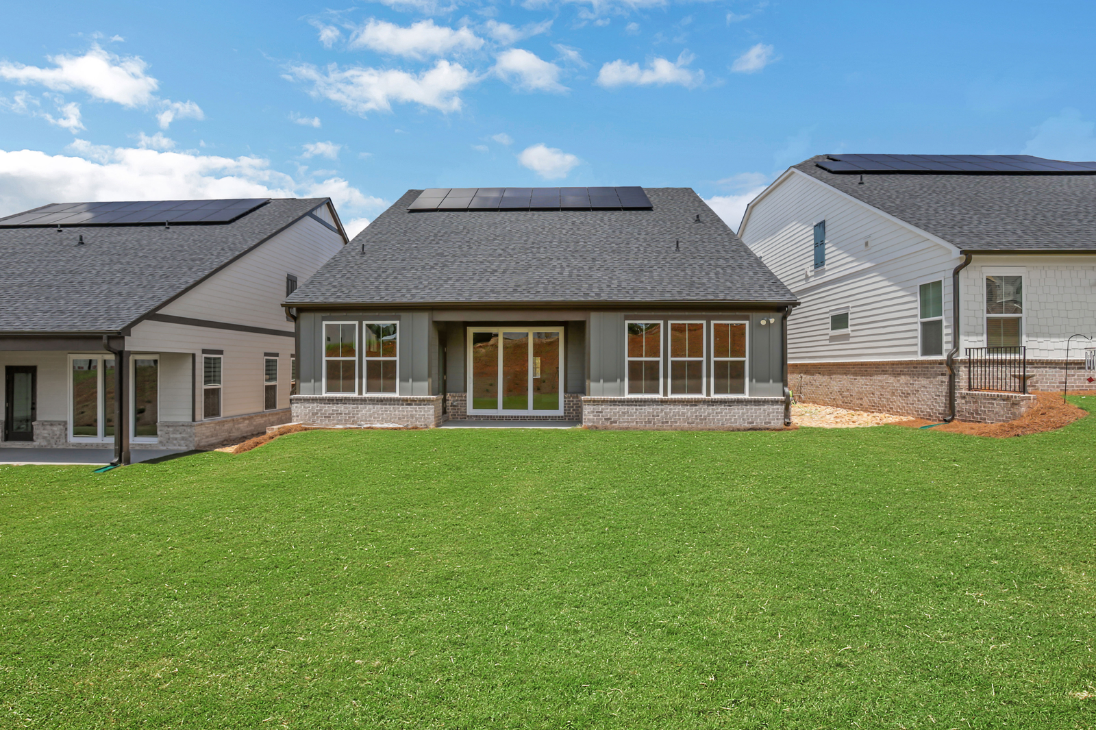 back of 1-story home with covered patio and lush grass