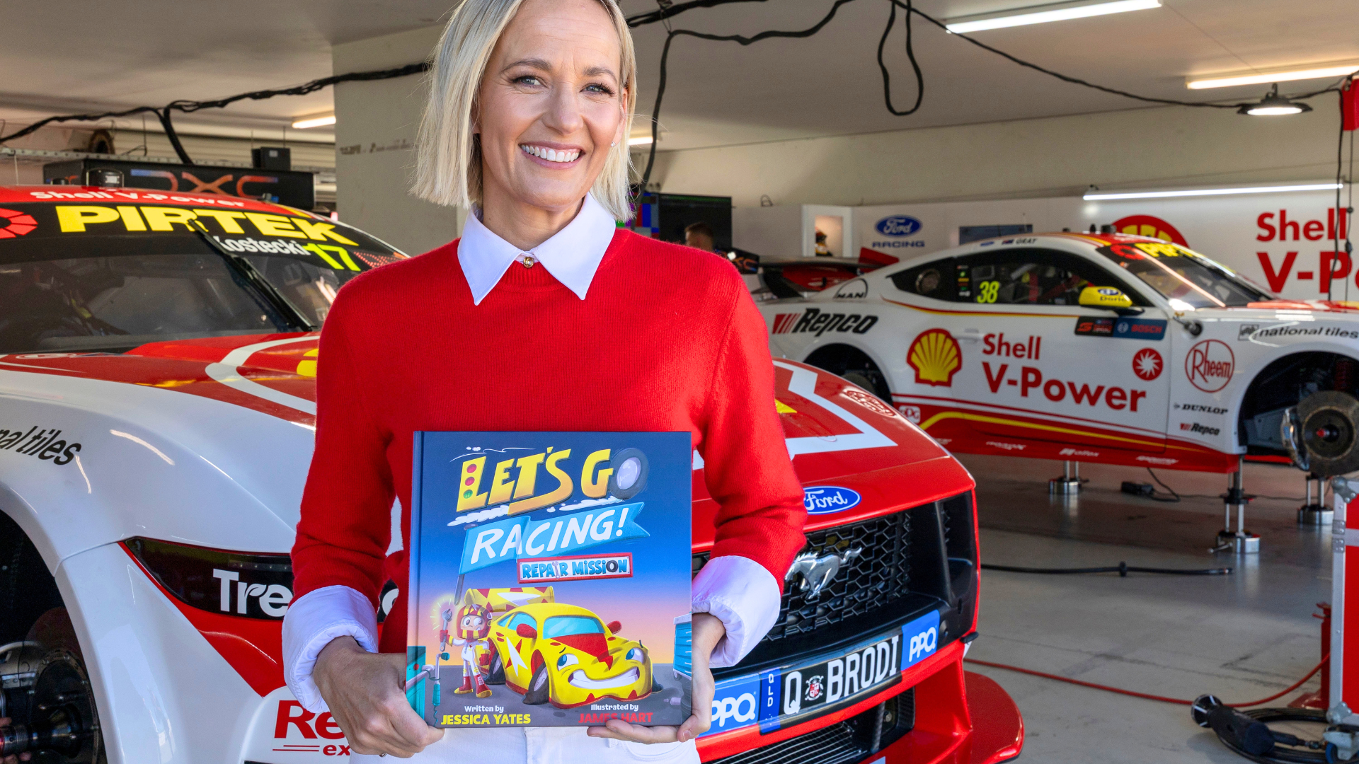 Image of Jess Yates holding her book, Let's go racing! Repair mission