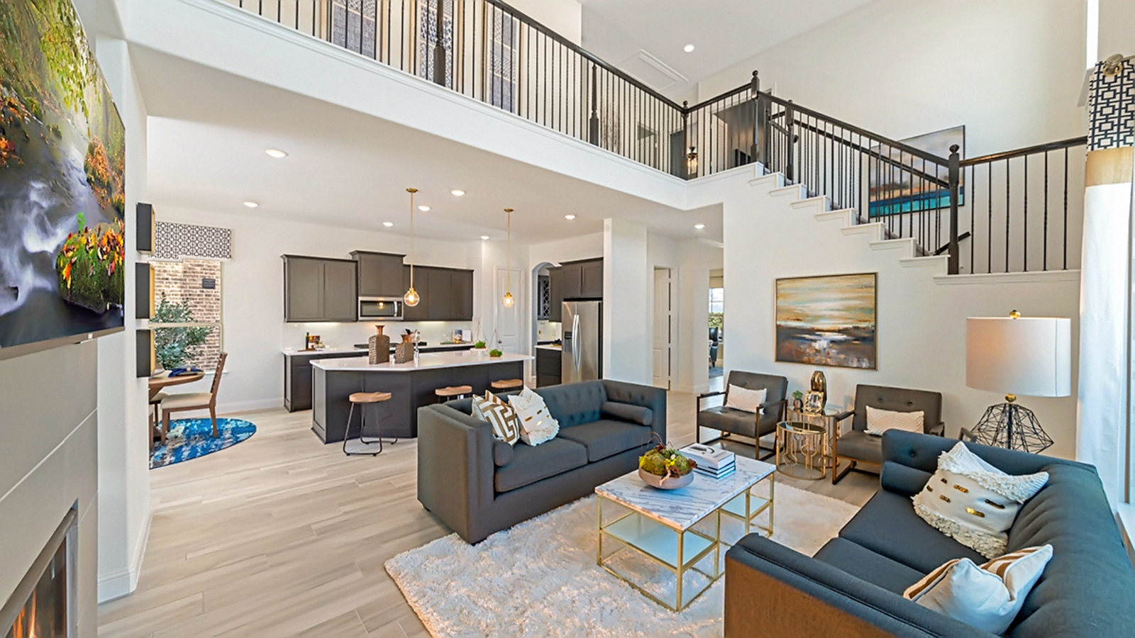 great room with wood flooring, two-story ceiling, and a fireplace
