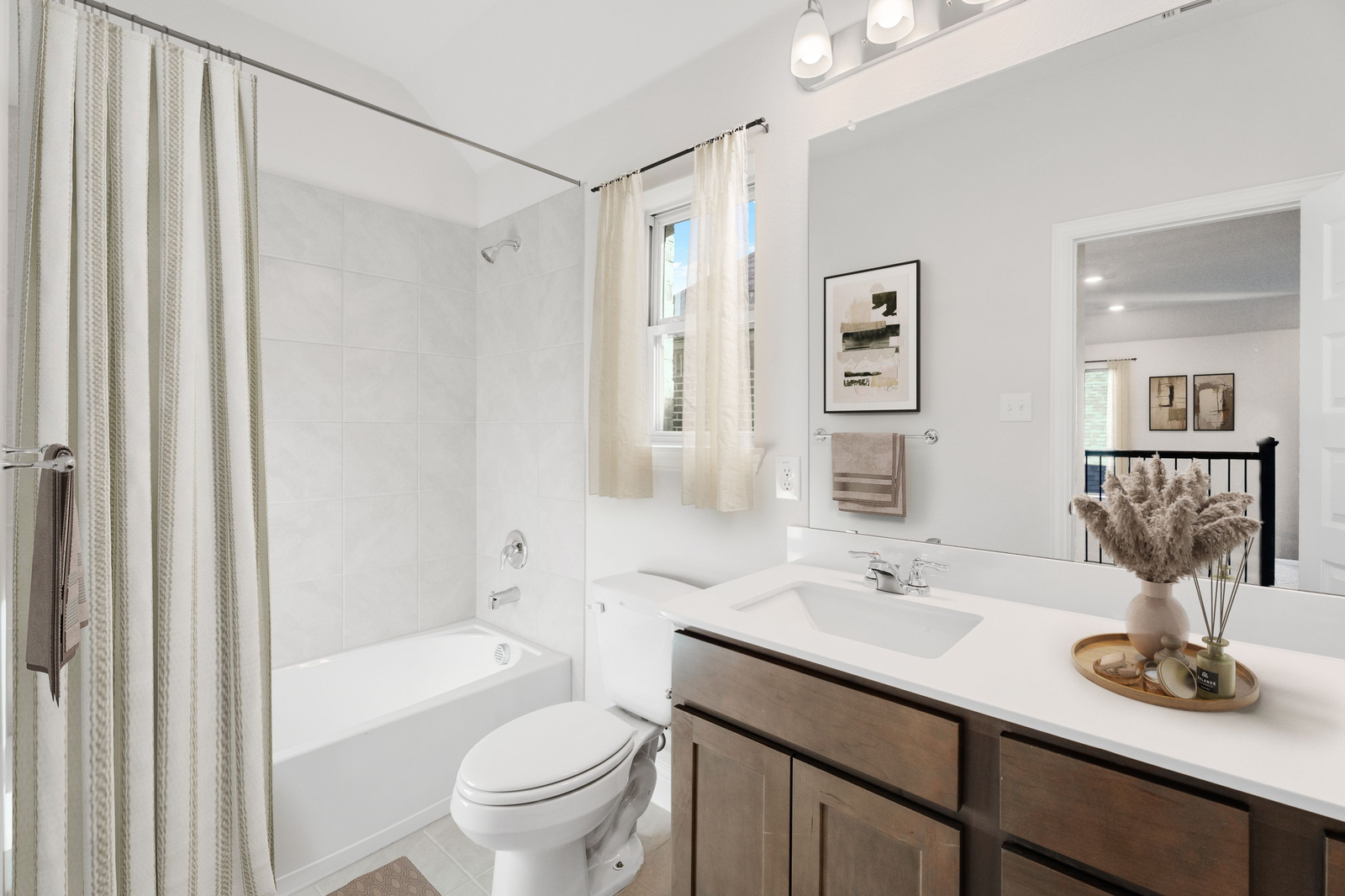 secondary bathroom with wood cabinets, white countertops, and a shower and tub combination