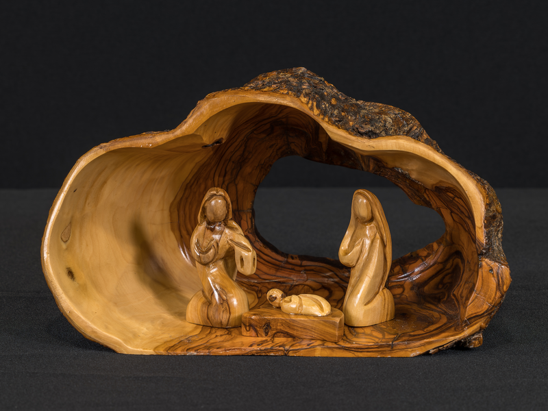 A hollowed-out portion of an olive tree trunk serves as the stable for this crèche and contains the Holy Family.