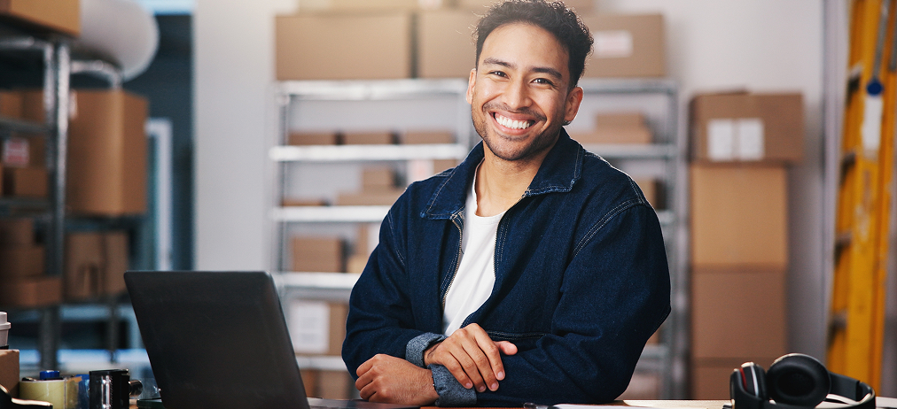 Professional working at a laptop in a warehouse office.