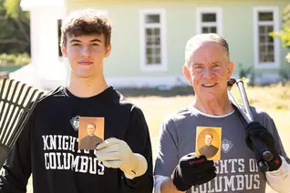 Joe McGivney and his son, Colin, hold cards with the prayer for the canonization