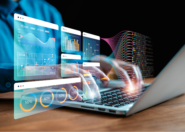 A person's hands are typing on a laptop keyboard, overlaid with several transparent, colorful digital dashboards displaying charts, graphs, and data visualizations.