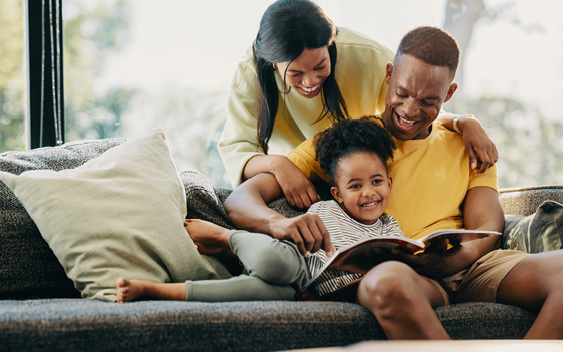 A person and person reading a book to a child
