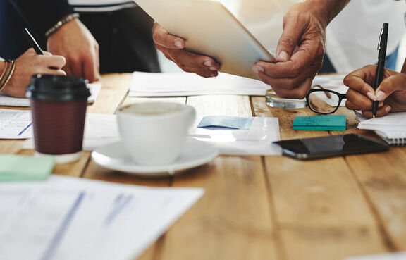 Group of people standing around a table discussing ideas
