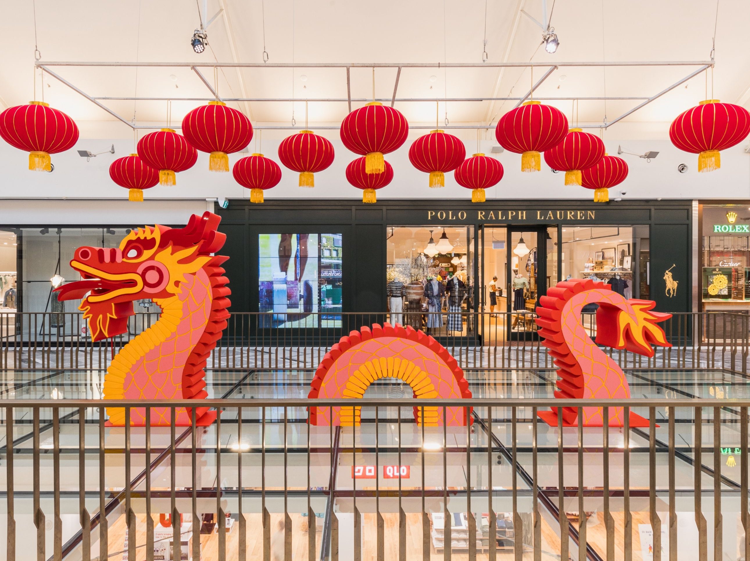 Lunar New Year display in a shopping centre with lanterns hanging above a decorative dragon.