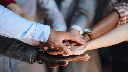 group of people with their hands piled on top of each other