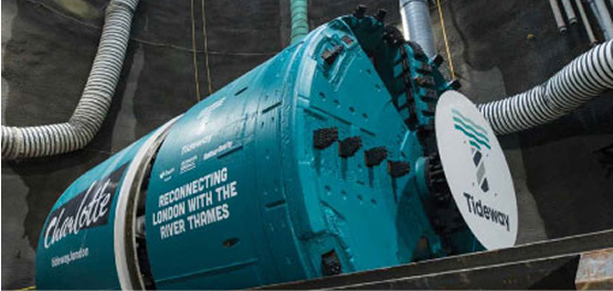 A large, teal-colored tunnel boring machine, named 'Charlotte,' with the Tideway project logo visible, inside a deep underground tunnel.
