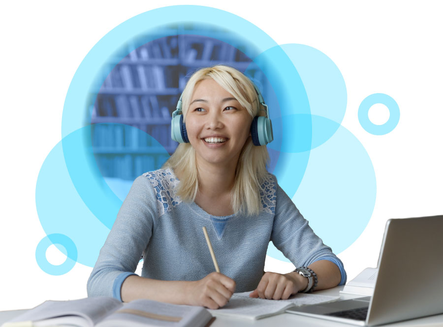 A young woman with blonde hair, wearing headphones, smiles as she takes notes at a desk in front of a laptop. Decorative blue circles in the background