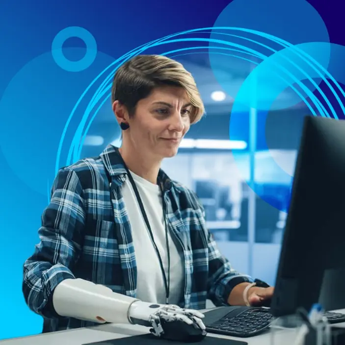 Person with a prosthetic arm working on a computer in a modern office setting, with a blue abstract background.