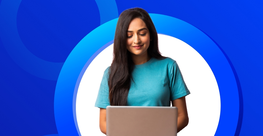 Smiling young woman looking at laptop screen
