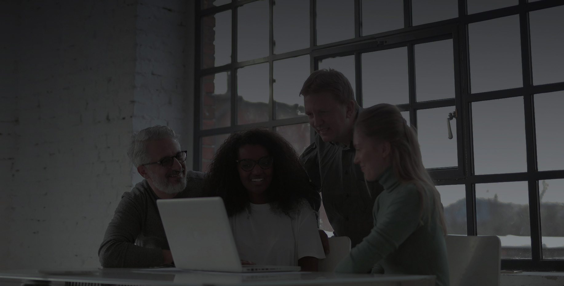 Four experts collaborating around a computer