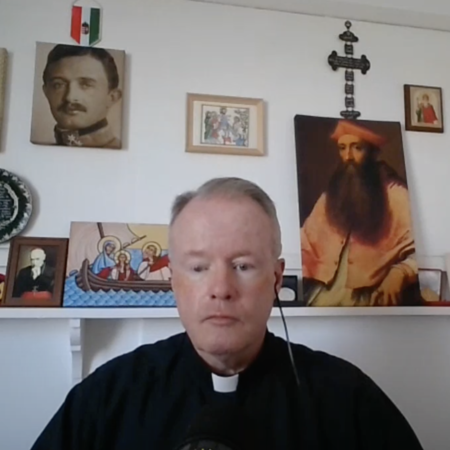 Father Kiely sitting during a webcam interview.