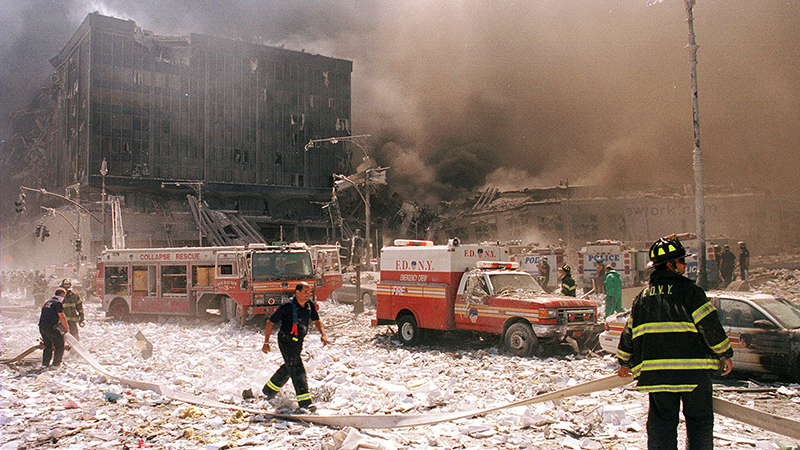New York City firefighters and other emergency personnel survey the World Trade Center collapse Sept. 11, 2001.