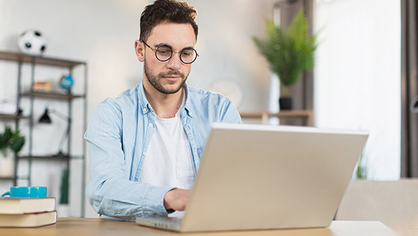 man typing into his laptop