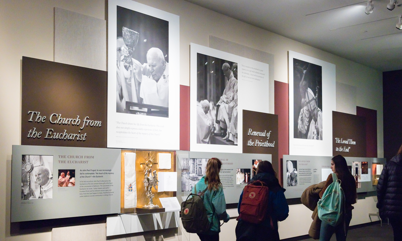 A groups of pilgrims walking through the Shrine's permanent exhibit