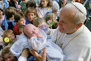 Pope John Paul II blesses a baby in Ars, France, Oct. 6, 1986.