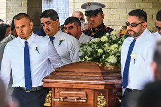 Pallbearers, including U.S. Marine Christian Garcia, carry the caskets of Irma and Joe Garcia