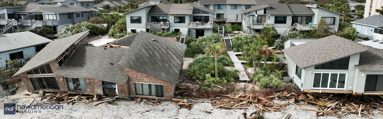 Damaged neighborhood homes with siding blown off of the houses