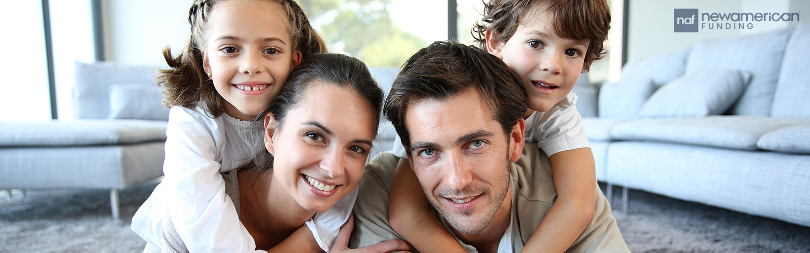 A happy white family plays in the living room of their home