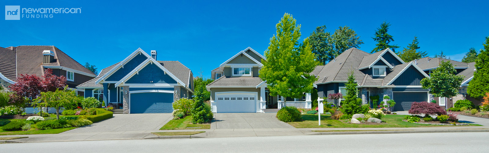 A row of vinyl and stone homes with well maintained lawns