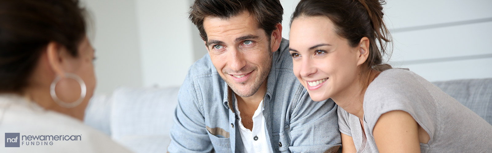 A man and woman smile across a table at a woman