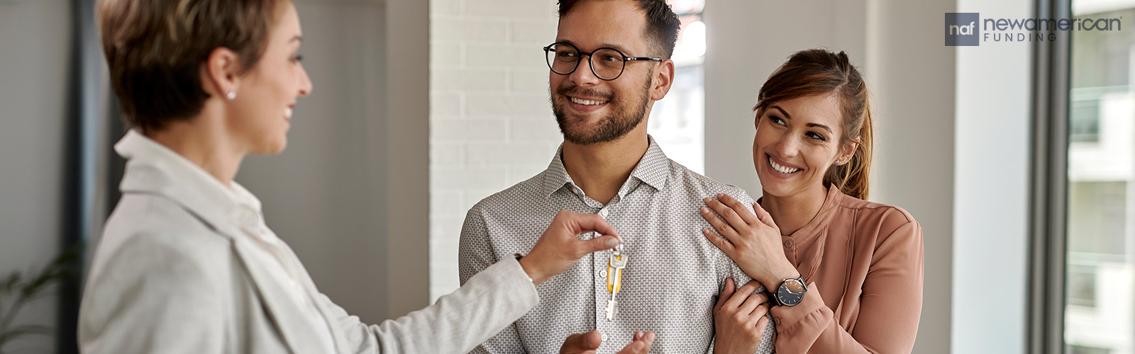 real estate agent hands homebuyers their house keys