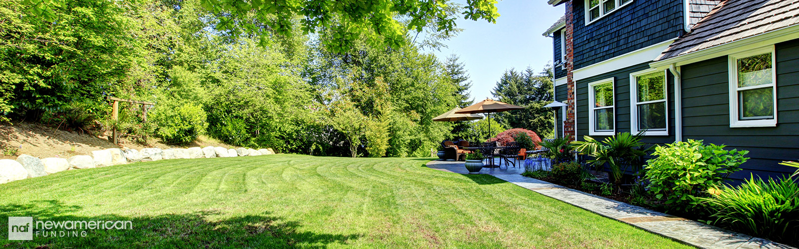A big freshly mowed back yard of a nice house 