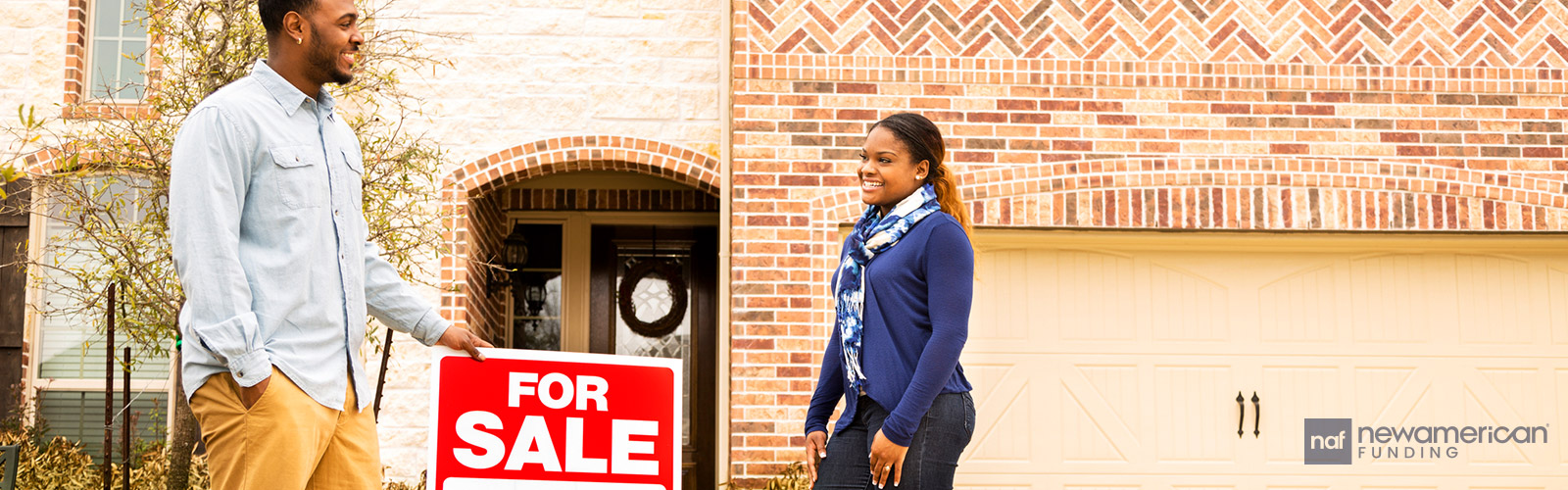 Borrower and real estate agent in from of a home with a for sale sign